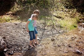 girls standing near stream