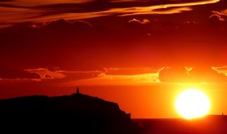 silhouette of a lighthouse on the background of a beautiful sunset