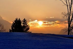 sunrise in the clouds over a winter landscape