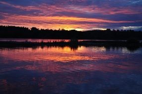 reflection of pink-purple sunset on the surface of the lake