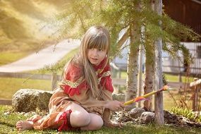 Little girl in colorful Indian costume playing on the field