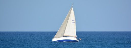 Boat with a white sail on the water, fuerteventura