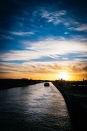 Single boat floating on a river at the sunset