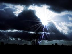 mystical landscape, flash and sunshine at thunderstorm clouds