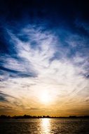 colorful sunset with bright sun over the lake