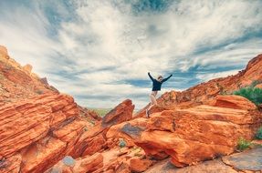 girl jumping brown rock