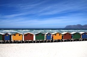row of beachfront colored cottages on the coast