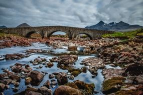 thunderclouds over a stone bridge in scotland