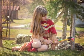 Child in an Indian suit sitting in the park