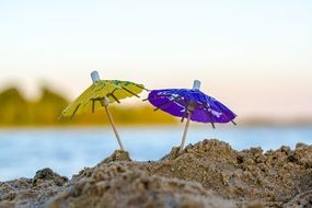 two cocktail umbrellas on the beach