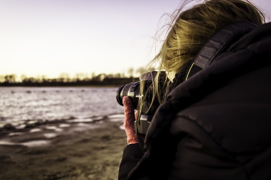 professional camera woman near beach scene