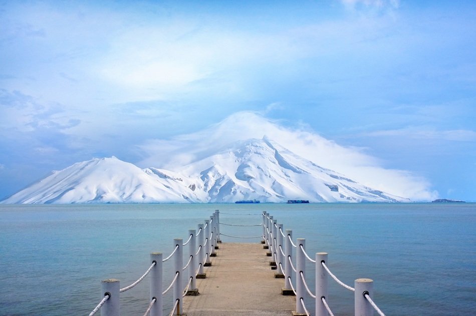 wooden pier on the background of snowy mountains