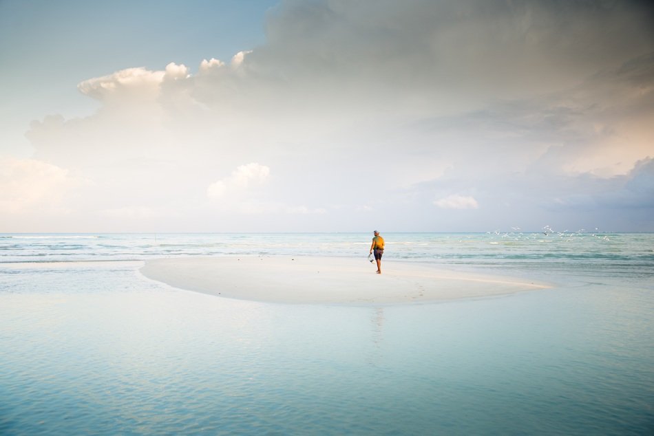 man in sea on white island