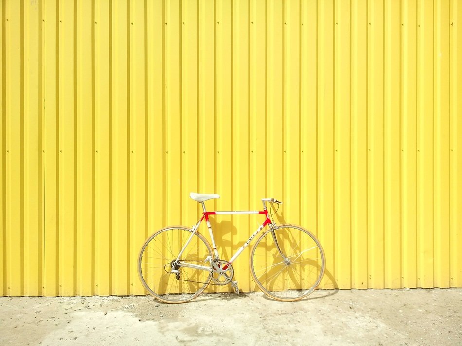 sports bicycle parked at yellow wall