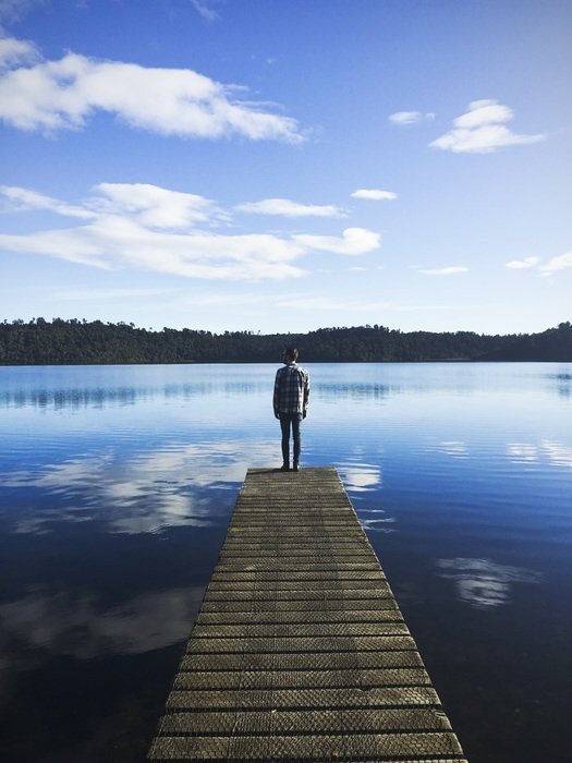 man on the wooden pier on the lake