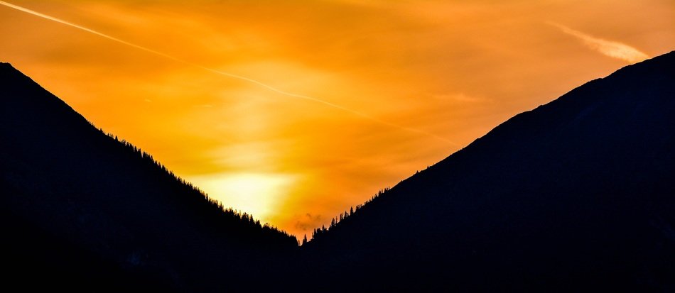the mountains in the background of the bright sunrise