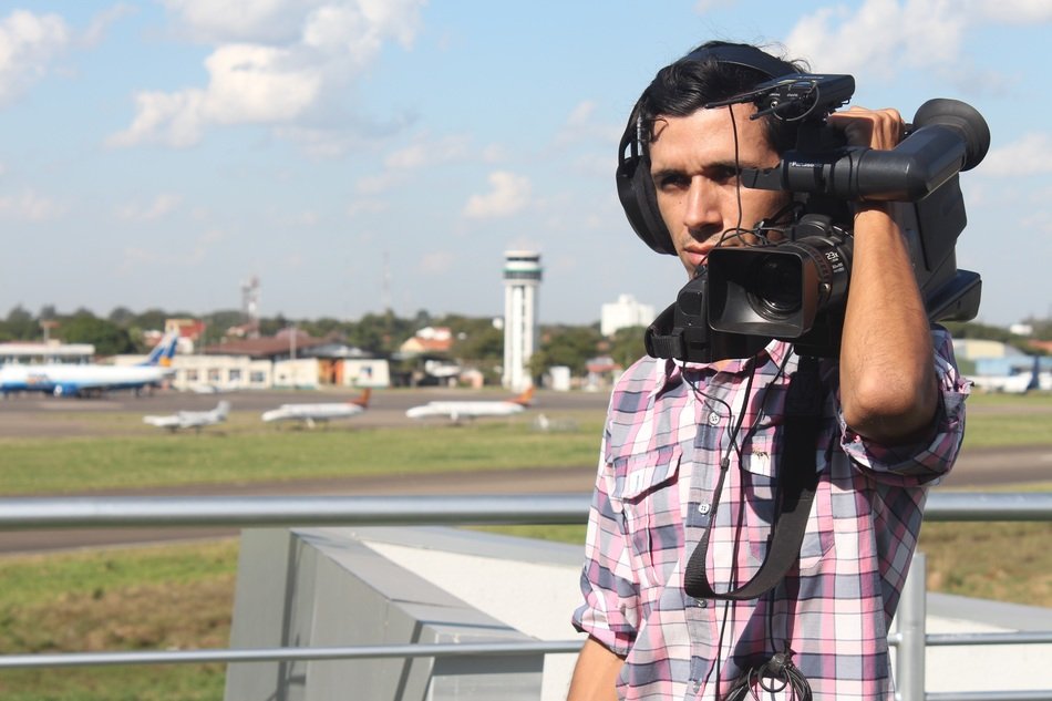 a man with a video camera on the background of aircraft