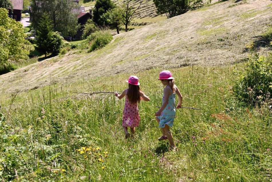 girls play with sticks in nature