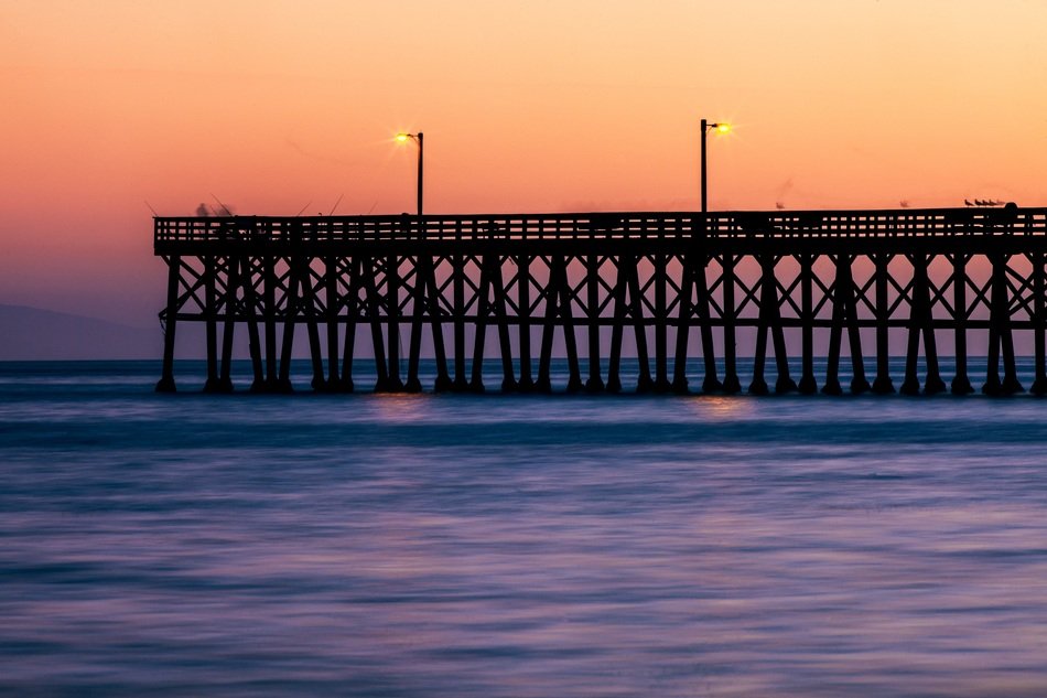 lampposts on the sea pier on the background of pink sunset
