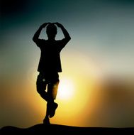 silhouette of a boy doing yoga in front the sunset