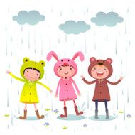 Kids wearing colorful raincoats playing on rainy day