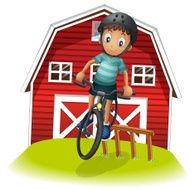 boy playing with his bike in front of the barnhouse