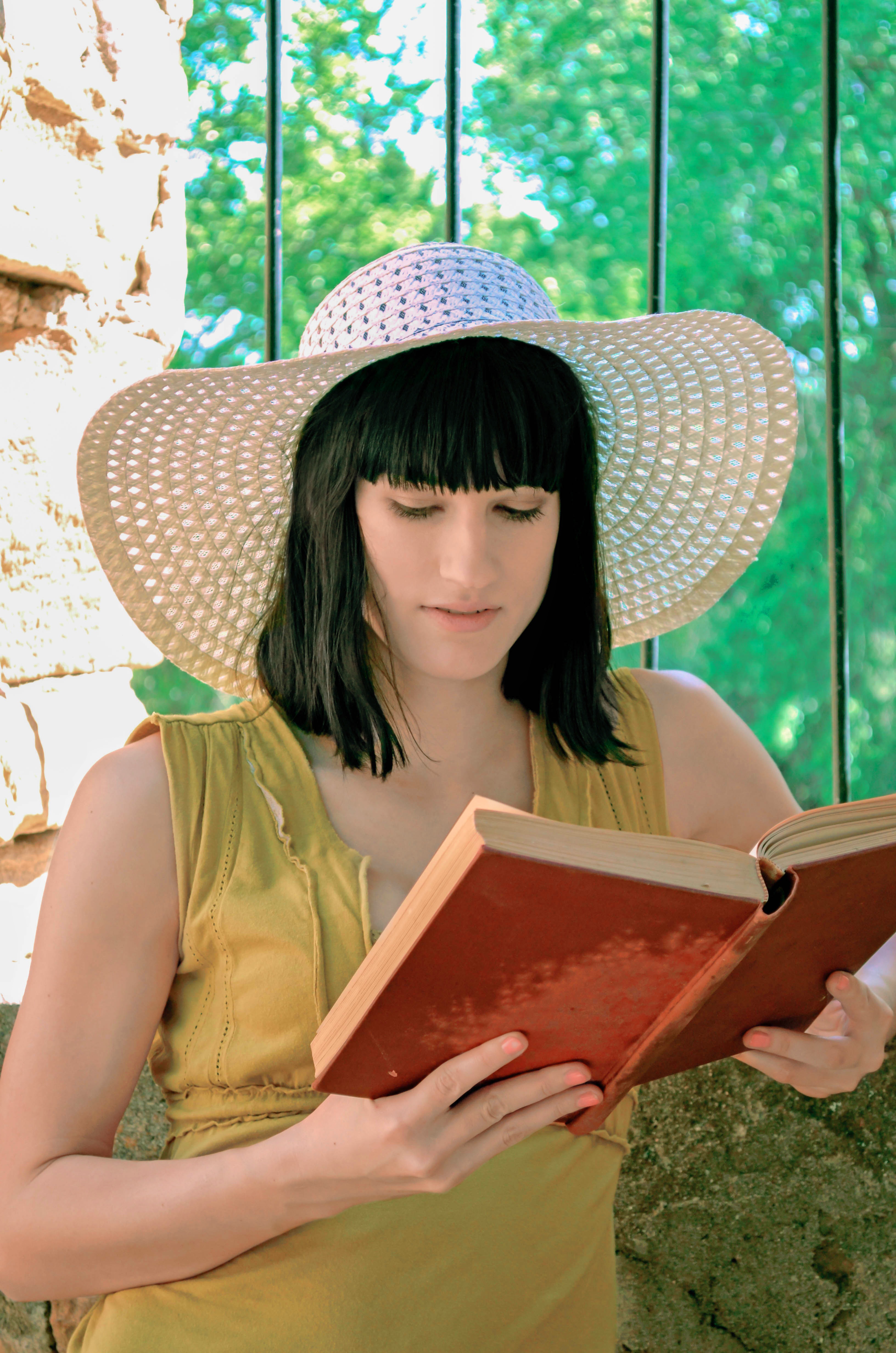 Girl in a straw hat is reading a book free image download