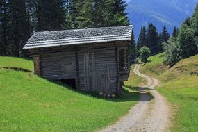 A path near a log cabin on the background of picturesque Alps