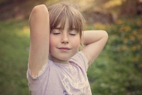 Little girl in relaxed pose outdoors