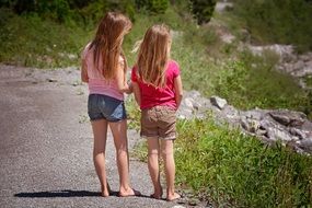 blonde girl pair on road, aback view