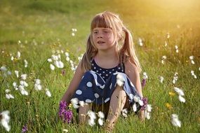 cute girl sitting on the meadow