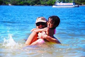 mother and daughter swim in the sea