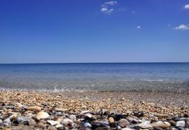 pebbles on the beach by the sea under blue sky
