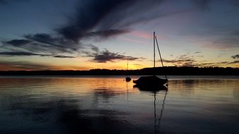 mirror image of a sailing boat in the water