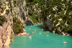 boats on turquoise water in scenic gorge, france, ardeche