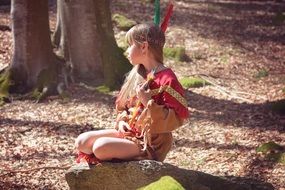 girl sitting on stone in forest indians