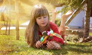 Little girl with long blond hair in the glare of the evening sun