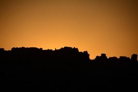 rock formations silhouette at orange sky, usa, utah, arches national park