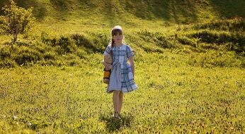 Little girl in a dress among nature