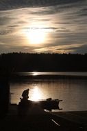Fisherman on a boat on the lake during sunset