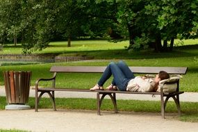 girl is resting on a park bench