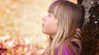 human child girl face blond near tree