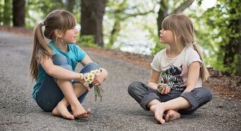 two little girls among the road in the forest