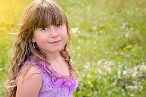 Little girl with long curly hair on nature background
