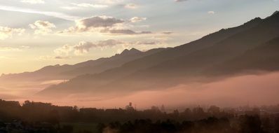 morning fog over the village at the foot of the mountain