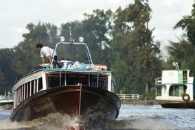 A man on a boat rides on the river