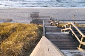 wooden staircase to sand beach at north sea, germany, sylt