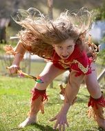 Young fair-haired girl playing active games in the park