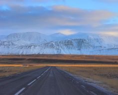 asphalt highway in the background of snowy mountains