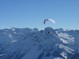 paragliding over the Alpine mountains in Austria on a sunny day